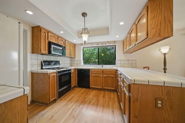 2173 Oak Ridge Dr, Redding, CA 96001 - kitchen featuring stove, stainless steel microwave, black dishwasher, light wood finished floors, and a raised ceiling