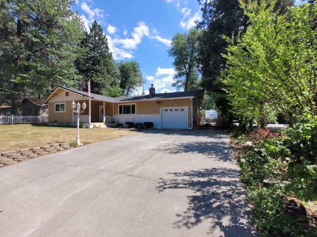 37023 Park Ave, Burney, CA 96013 - ranch-style house with an attached garage, asphalt driveway, and a chimney