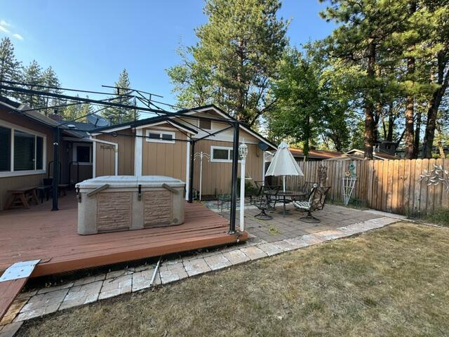 37023 Park Ave, Burney, CA 96013 - deck with a hot tub, a fenced backyard, and a patio area