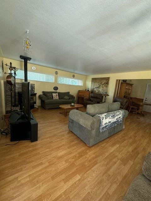 37023 Park Ave, Burney, CA 96013 - living area featuring a wood stove, light wood finished floors, and a textured ceiling