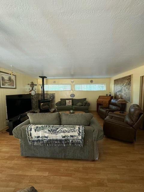 37023 Park Ave, Burney, CA 96013 - living room with a wood stove, wood finished floors, and a textured ceiling