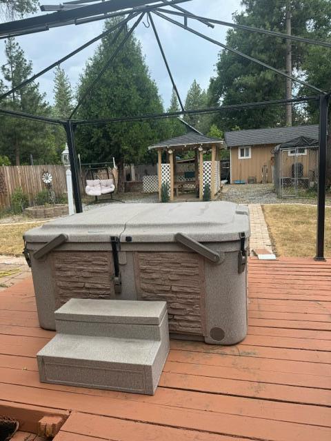 37023 Park Ave, Burney, CA 96013 - wooden terrace with a hot tub, a storage unit, and a gazebo