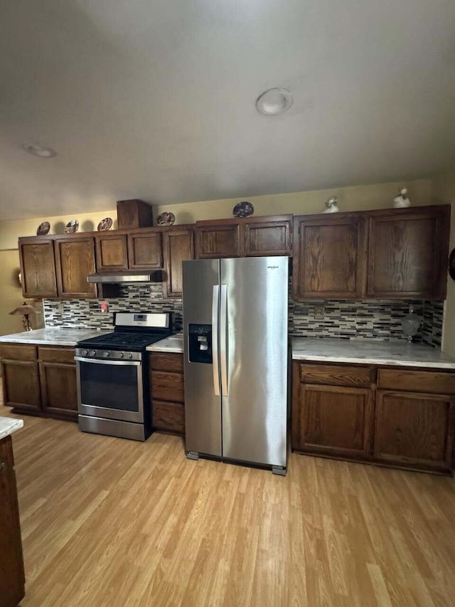 37023 Park Ave, Burney, CA 96013 - kitchen featuring stainless steel appliances, under cabinet range hood, light wood-style flooring, and tasteful backsplash