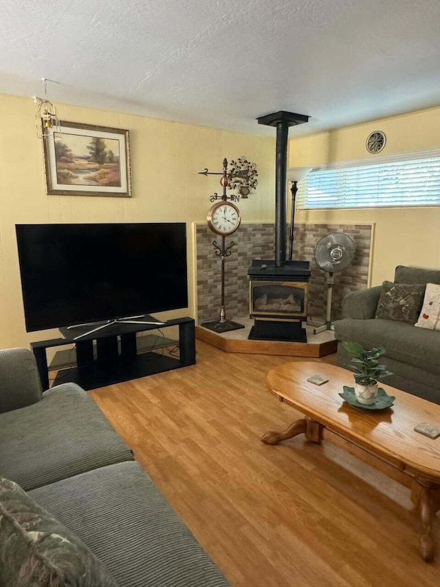 37023 Park Ave, Burney, CA 96013 - living room featuring wood finished floors, a wood stove, and a textured ceiling
