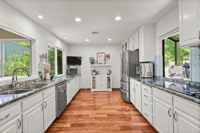 409 Ridgecrest Trl, Redding, CA 96003 - kitchen with appliances with stainless steel finishes, open shelves, white cabinetry, recessed lighting, and dark stone counters