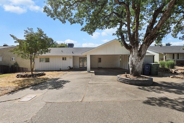 2955 Shasta St, Redding, CA 96001 - ranch-style home with concrete driveway, board and batten siding, a carport, and french doors