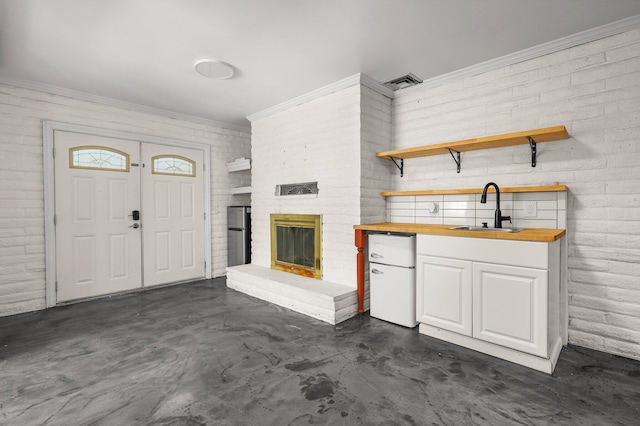 2955 Shasta St, Redding, CA 96001 - unfurnished living room featuring concrete floors, crown molding, and a fireplace