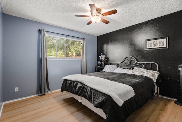 3921 Mercury Dr, Redding, CA 96002 - bedroom featuring wood finished floors, a textured ceiling, and a ceiling fan