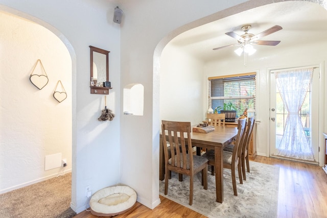 3274 Quartz Hill Rd, Redding, CA 96003 - dining area with arched walkways, ceiling fan, and light wood-type flooring