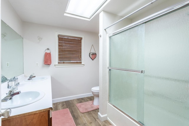 3274 Quartz Hill Rd, Redding, CA 96003 - bathroom featuring wood finished floors, double vanity, toilet, enclosed tub / shower combo, and baseboards
