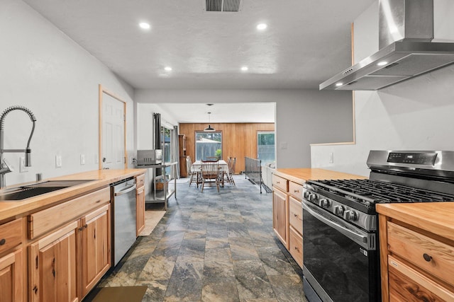 3371 Bardick Rd, Anderson, CA 96007 - kitchen featuring appliances with stainless steel finishes, butcher block counters, wall chimney exhaust hood, recessed lighting, and dark stone finish floors