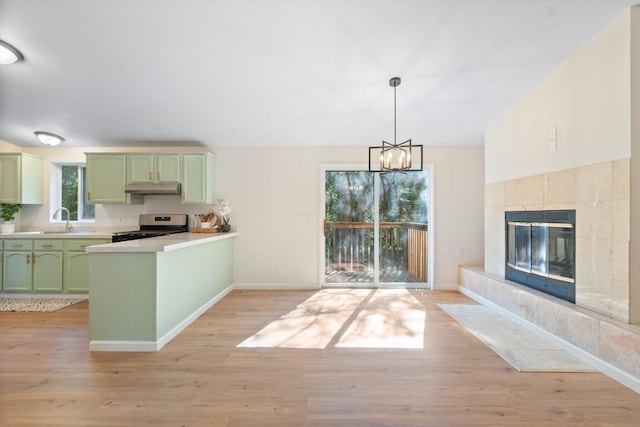 7727 Pegnan Rd, Shingletown, CA 96088 - kitchen featuring green cabinetry, stainless steel gas range oven, under cabinet range hood, a peninsula, and light countertops