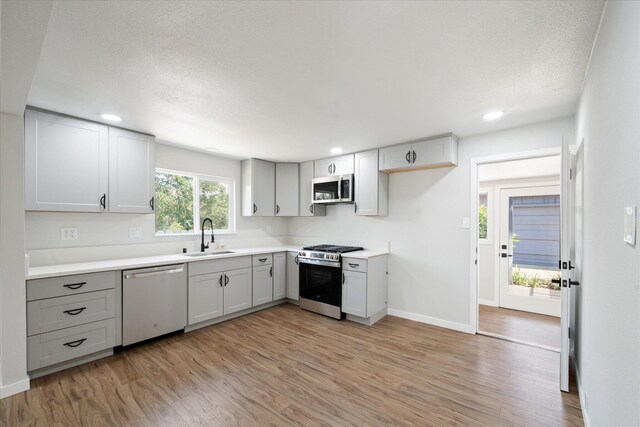 1949 Montana Ave, Shasta Lake, CA 96019 - kitchen featuring stainless steel appliances, a sink, light wood finished floors, baseboards, and recessed lighting