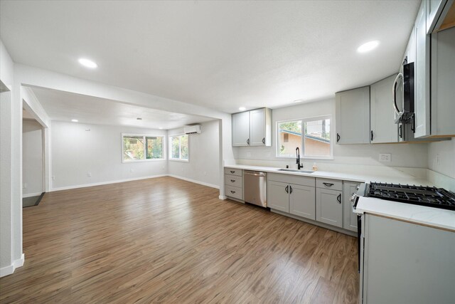 1949 Montana Ave, Shasta Lake, CA 96019 - kitchen featuring appliances with stainless steel finishes, open floor plan, a sink, a wall mounted AC, and plenty of natural light