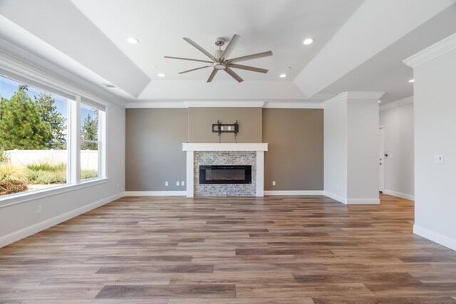 4537 Risstay Way, Shasta Lake, CA 96019 - unfurnished living room featuring a ceiling fan, a raised ceiling, crown molding, wood finished floors, and a fireplace
