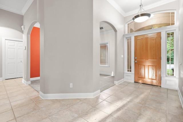 4230 Brittany Dr, Redding, CA 96002 - entrance foyer featuring arched walkways, crown molding, a towering ceiling, and light tile patterned floors