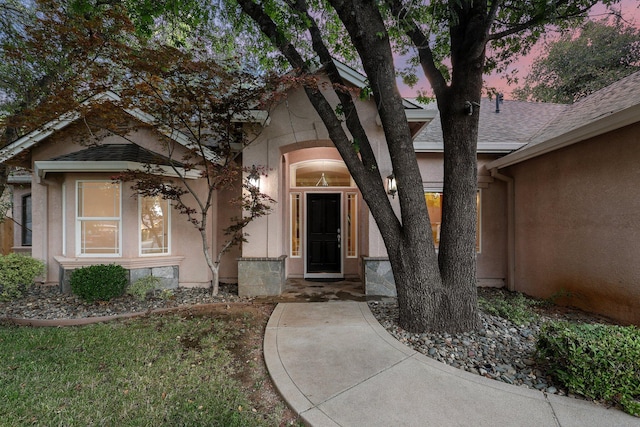 4230 Brittany Dr, Redding, CA 96002 - view of exterior entry with stucco siding and a shingled roof