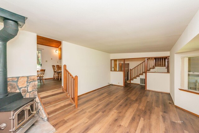 131 Northwoods Ests, Trinity Center, CA 96091 - unfurnished living room with a wood stove, wood finished floors, and stairway