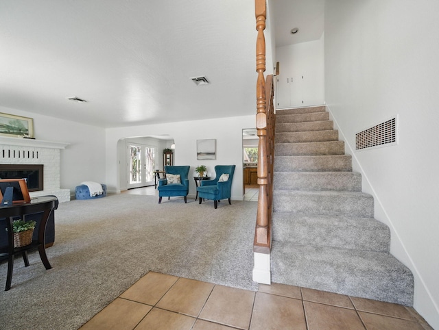 4050 Oro Ct, Redding, CA 96001 - stairs with arched walkways, carpet flooring, tile patterned floors, and a brick fireplace
