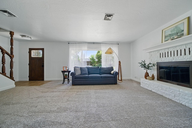 4050 Oro Ct, Redding, CA 96001 - living area with carpet floors, stairway, a brick fireplace, and a textured ceiling