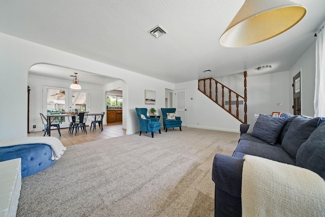 4050 Oro Ct, Redding, CA 96001 - tiled living room featuring arched walkways, carpet flooring, and stairway