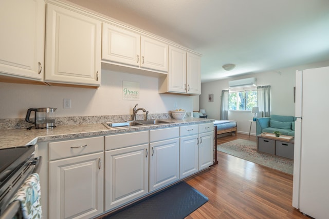 9733 Hidden Ln, Palo Cedro, CA 96073 - kitchen with stainless steel stove, wood finished floors, an AC wall unit, light countertops, and white cabinets