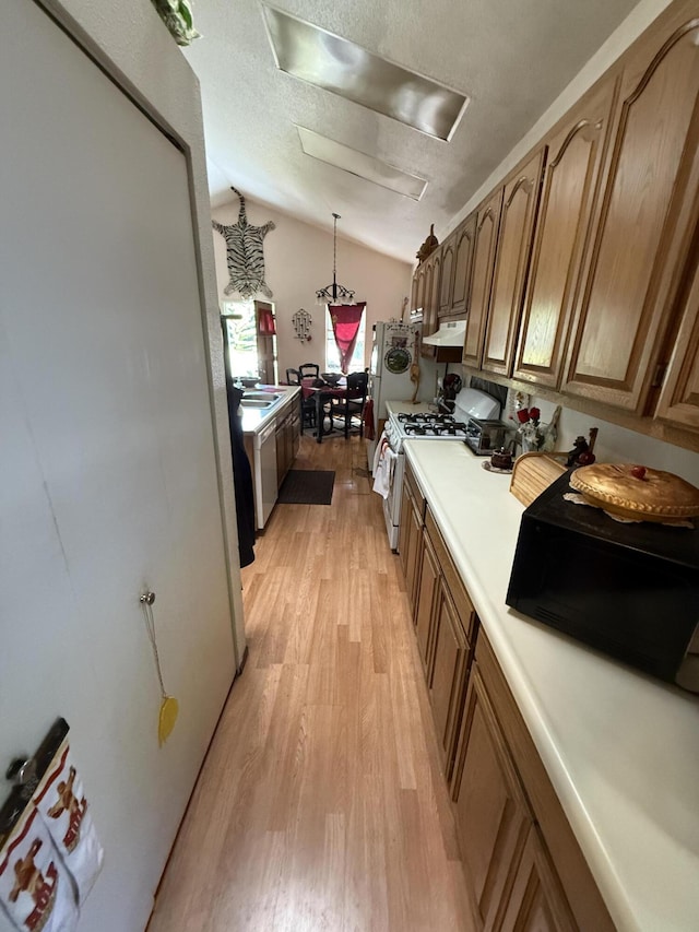 728 Lincoln St, Red Bluff, CA 96080 - kitchen featuring under cabinet range hood, light countertops, lofted ceiling, light wood-style floors, and gas range gas stove