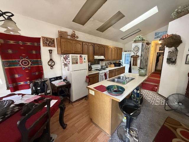 728 Lincoln St, Red Bluff, CA 96080 - kitchen with white appliances, lofted ceiling, light wood-type flooring, light countertops, and under cabinet range hood