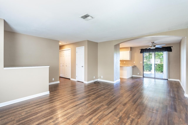 830 Redwood Blvd, Redding, CA 96003 - unfurnished living room with arched walkways, dark wood finished floors, and ceiling fan