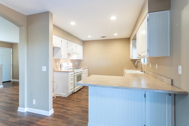830 Redwood Blvd, Redding, CA 96003 - kitchen with white range with gas stovetop, a peninsula, under cabinet range hood, dark wood-style floors, and recessed lighting