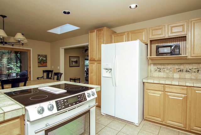 9259 Kings Ct, Shingletown, CA 96088 - kitchen with white refrigerator with ice dispenser, stainless steel range with electric cooktop, black microwave, light brown cabinetry, and recessed lighting