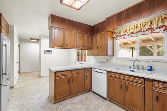 910 Hallmark Dr, Redding, CA 96001 - kitchen featuring white dishwasher, high quality fridge, a peninsula, and brown cabinetry