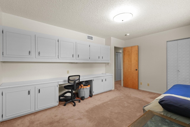 910 Hallmark Dr, Redding, CA 96001 - bedroom featuring light carpet, a textured ceiling, built in study area, and a closet