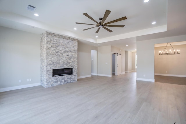 19450 Vista Del Monte Ct, Redding, CA 96003 - unfurnished living room with a barn door, ceiling fan, a raised ceiling, light wood-type flooring, and recessed lighting
