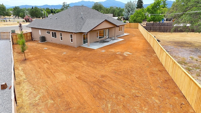 19450 Vista Del Monte Ct, Redding, CA 96003 - back of house featuring stucco siding, a shingled roof, a mountain view, a patio area, and a fenced backyard