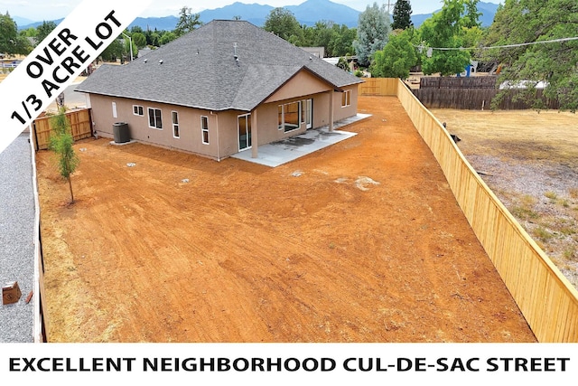 19450 Vista Del Monte Ct, Redding, CA 96003 - back of property featuring a mountain view, stucco siding, roof with shingles, a patio area, and a fenced backyard