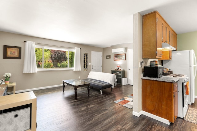 2647 Shasta View Dr, Redding, CA 96002 - kitchen with white range with gas cooktop, black microwave, under cabinet range hood, dark wood-type flooring, and brown cabinetry