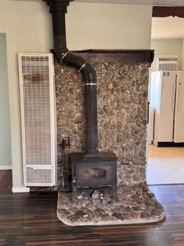 1637 Green St, Redding, CA 96002 - detailed view of freestanding refrigerator, a wood stove, a heating unit, and wood finished floors