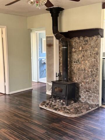 1637 Green St, Redding, CA 96002 - unfurnished living room with a ceiling fan, a wood stove, and wood finished floors