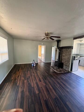 1637 Green St, Redding, CA 96002 - unfurnished living room with a wood stove, wood finished floors, and ceiling fan