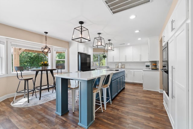 4676 Dandelion Dr, Redding, CA 96002 - kitchen featuring black appliances, blue cabinets, white cabinetry, backsplash, and a kitchen island