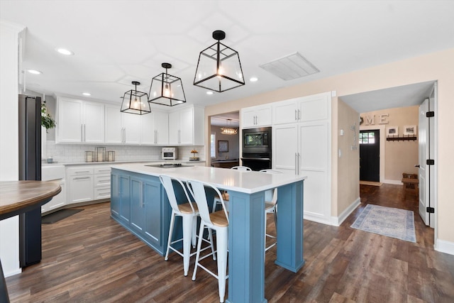 4676 Dandelion Dr, Redding, CA 96002 - kitchen featuring black appliances, white cabinetry, a kitchen island, recessed lighting, and dark wood-style floors