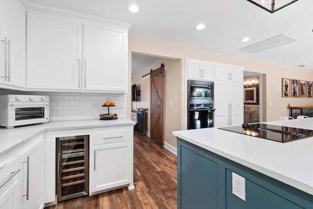 4676 Dandelion Dr, Redding, CA 96002 - kitchen featuring beverage cooler, black appliances, a barn door, recessed lighting, and white cabinetry