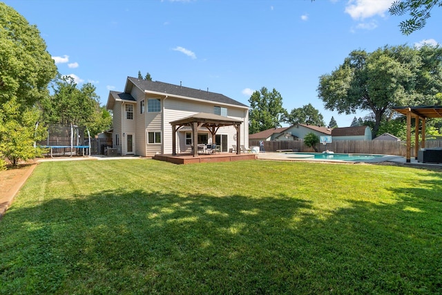 4676 Dandelion Dr, Redding, CA 96002 - rear view of property with a gazebo, a trampoline, a fenced backyard, and a deck