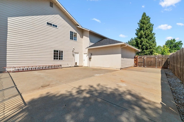 4676 Dandelion Dr, Redding, CA 96002 - view of side of home with a gate, concrete driveway, roof with shingles, and a patio area