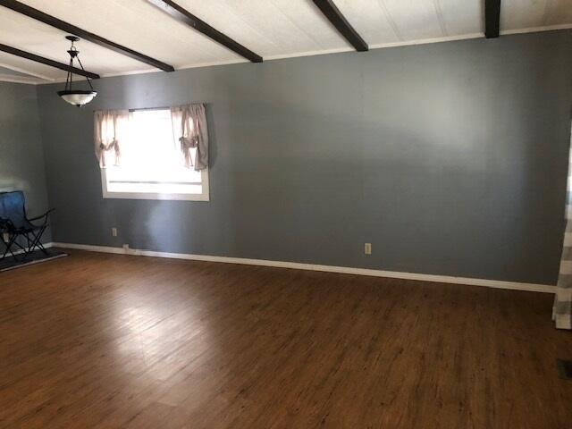 1064 Eagle Nest Rd, Redding, CA 96003 - unfurnished living room featuring beam ceiling and dark wood finished floors