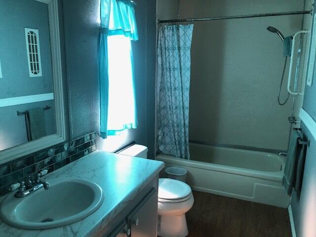 1064 Eagle Nest Rd, Redding, CA 96003 - full bathroom featuring vanity, wood finished floors, shower / bath combo with shower curtain, and healthy amount of natural light