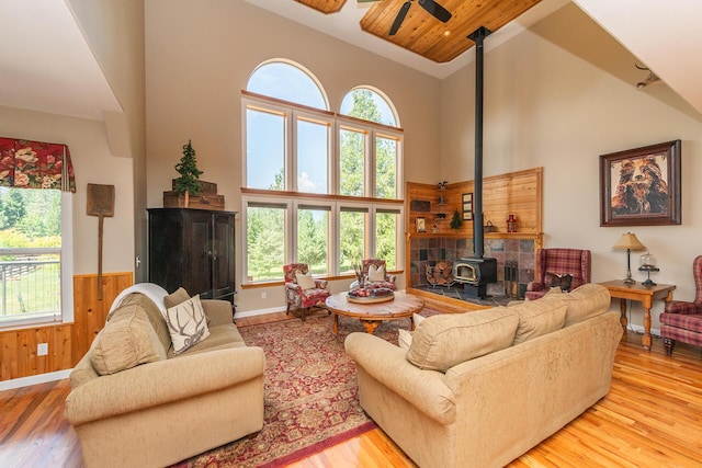 100 Eleanore Ln, Trinity Center, CA 96091 - living room with a wood stove, high vaulted ceiling, wood finished floors, ceiling fan, and wainscoting