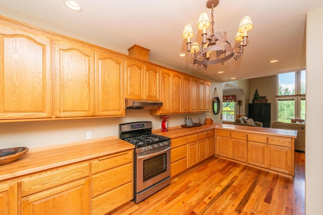 100 Eleanore Ln, Trinity Center, CA 96091 - kitchen with stainless steel range with gas stovetop, under cabinet range hood, light wood-style flooring, a chandelier, and recessed lighting