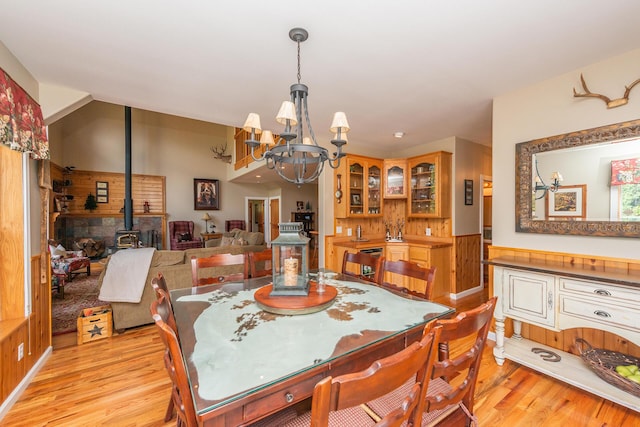 100 Eleanore Ln, Trinity Center, CA 96091 - dining room with a chandelier, a wood stove, light wood-style flooring, and wainscoting
